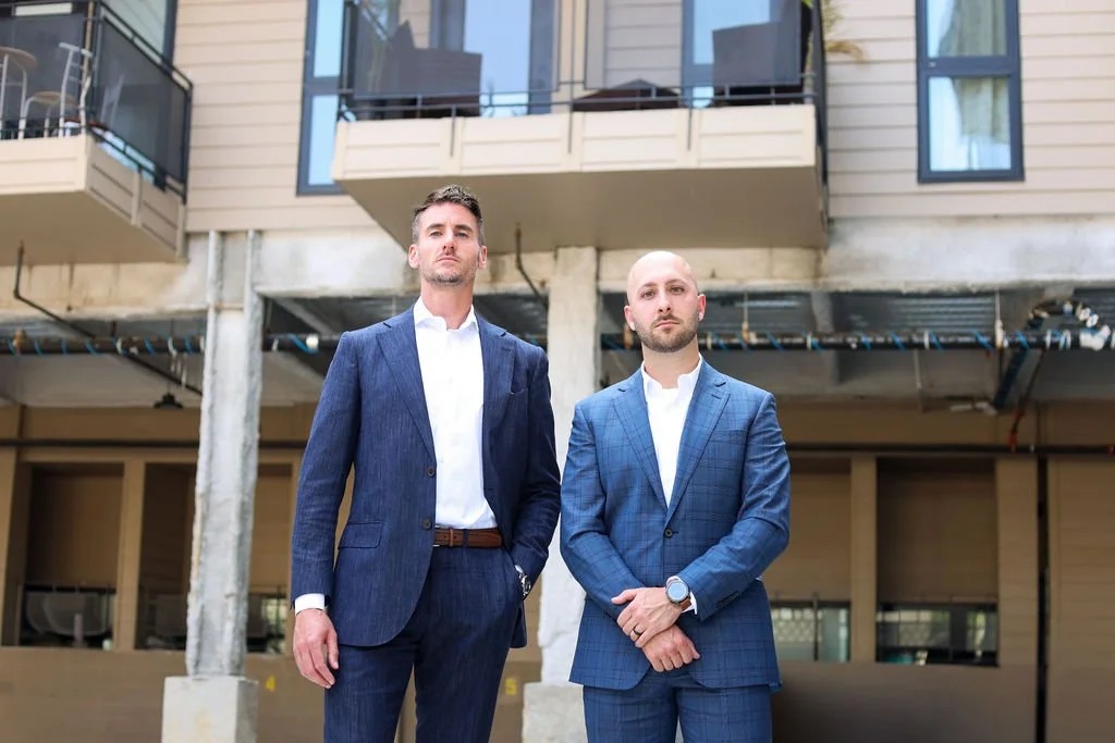Ryan McManus and Brandon Ribeiro of Agent PHL standing outside a Philadelphia apartment building